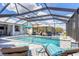 Backyard oasis with a pool, hot tub, lounge chairs, and landscaping inside of a screened enclosure at 226 W Pine Valley Ln, Rotonda West, FL 33947