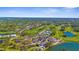 Aerial image of a golf community showcasing a golf course, tennis courts, lake, and clubhouse at 2292 Harrier Way, Nokomis, FL 34275