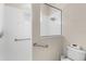 Clean, white tiled shower with safety bars and glass partition for accessible bathing at 2292 Harrier Way, Nokomis, FL 34275