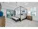 Bright bedroom featuring a four-poster bed, wood furniture, seating area and plenty of natural light at 265 Bocelli Dr, Nokomis, FL 34275