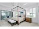 Bright bedroom featuring a four-poster bed, wood furniture, seating area and plenty of natural light at 265 Bocelli Dr, Nokomis, FL 34275
