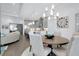 Cozy dining area with a round table, six chairs, chandelier, and view to the open concept kitchen and living room at 265 Bocelli Dr, Nokomis, FL 34275