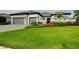 Attractive home exterior with a green lawn, mature landscaping, and a multi-car garage at 265 Bocelli Dr, Nokomis, FL 34275