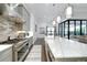 Bright kitchen boasts stainless steel appliances, large island with quartz countertops, and a view of the water at 265 Bocelli Dr, Nokomis, FL 34275