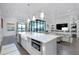 Open concept kitchen with a center island, farm sink, stainless appliances, view to the backyard and living room at 265 Bocelli Dr, Nokomis, FL 34275