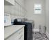 Neat laundry room featuring modern appliances, storage cabinets, neutral gray color palette and a patterned accent wall at 265 Bocelli Dr, Nokomis, FL 34275