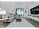 Spacious living room with a large sectional, white shiplap accent wall, and sliding glass doors to the lanai at 265 Bocelli Dr, Nokomis, FL 34275