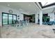 Spacious outdoor living area with dining table, comfortable seating, and serene water views through expansive glass sliders at 265 Bocelli Dr, Nokomis, FL 34275