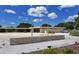 Modern beach building with a covered walkway, featuring well-maintained landscaping and ample parking under a partly cloudy sky at 328 Channel Ln, Nokomis, FL 34275