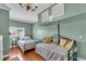 Cozy bedroom with two beds, wood floors, and neutral green walls, brightened by natural light at 328 Channel Ln, Nokomis, FL 34275