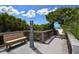 Inviting boardwalk with a bench and outdoor shower, leading to a pristine beach under a partly cloudy sky, perfect for relaxation at 328 Channel Ln, Nokomis, FL 34275