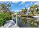 Waterfront home featuring a private dock with boat access surrounded by lush tropical landscaping at 328 Channel Ln, Nokomis, FL 34275