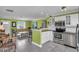 Open concept kitchen flows into the living room with stainless steel appliances and a breakfast bar area at 328 Channel Ln, Nokomis, FL 34275