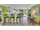 Bright kitchen with bar seating, stainless steel refrigerator, white cabinets, and adjacent dining area with outdoor view at 328 Channel Ln, Nokomis, FL 34275