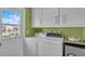 Laundry room with a side-by-side washer and dryer and storage cabinets, offering convenience and functionality at 328 Channel Ln, Nokomis, FL 34275