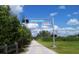 Inviting Legacy Trail entrance with clear signage, a smooth paved path, and lush greenery, perfect for outdoor activities at 328 Channel Ln, Nokomis, FL 34275