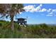 Picturesque lifeguard stand overlooking a serene beach, with palm trees and dune vegetation under a bright, partly cloudy sky at 328 Channel Ln, Nokomis, FL 34275