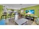 Open-concept living space with barstool seating, dining area, and a comfortable lounging area with a large screen TV at 328 Channel Ln, Nokomis, FL 34275