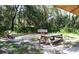 Tranquil shaded picnic area with a wooden table and benches, nestled among lush trees and vegetation, perfect for relaxation at 328 Channel Ln, Nokomis, FL 34275