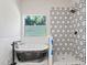 Modern bathroom with a freestanding tub and walk-in shower featuring hexagon tile at 3470 Elias Cir, North Port, FL 34288