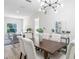 Dining room features natural light, modern chandelier, and seating for six at 3470 Elias Cir, North Port, FL 34288