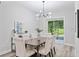 Bright dining room featuring a modern chandelier and elegant upholstered chairs at 3470 Elias Cir, North Port, FL 34288