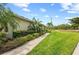 Side yard showcasing a lush lawn, mature trees, and an inviting view of a tranquil pond at 371 Capulet Dr, Venice, FL 34292