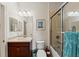 Cozy bathroom featuring a vanity with dark wood cabinets, shower with glass doors, and decorative accents at 371 Capulet Dr, Venice, FL 34292