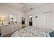 Bright bedroom featuring a decorative dresser, ceiling fan, and floral-patterned bedding at 371 Capulet Dr, Venice, FL 34292