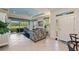Bright living room with tiled floor, view of the screen porch, and modern ceiling fan at 371 Capulet Dr, Venice, FL 34292