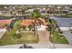 Expansive aerial view of the property with lush landscaping, a terracotta roof, and a brick driveway at 3819 Aves Island Ct, Punta Gorda, FL 33950