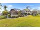 Beautiful backyard featuring a screened-in porch, green lawn, and mature tropical landscaping at 3819 Aves Island Ct, Punta Gorda, FL 33950