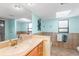 Bright bathroom with granite countertops, a large mirror and blue walls at 3819 Aves Island Ct, Punta Gorda, FL 33950