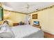 Bedroom featuring yellow walls, wood flooring, a ceiling fan, a desk, and a television at 3819 Aves Island Ct, Punta Gorda, FL 33950