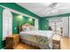 This bedroom features a floral bedspread, green walls, and a ceiling fan at 3819 Aves Island Ct, Punta Gorda, FL 33950