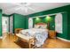 This bedroom features a floral bedspread, green walls and hardwood floors at 3819 Aves Island Ct, Punta Gorda, FL 33950