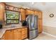 Kitchen features oak cabinets, granite counters, stainless steel appliances, and a side-by-side refrigerator at 3819 Aves Island Ct, Punta Gorda, FL 33950