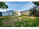 Spacious backyard featuring a screened-in pool area, white privacy fence, and mature landscaping at 420 Zephyr Rd, Venice, FL 34293