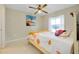 Bright bedroom featuring a ceiling fan, floral bedding, and a window providing natural light at 420 Zephyr Rd, Venice, FL 34293