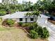 Charming home with lush landscaping, palm trees, a long driveway and an attached one car garage at 420 Zephyr Rd, Venice, FL 34293
