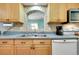 Bright kitchen featuring wood cabinets, stainless steel appliances, tile flooring, and neutral countertops at 420 Zephyr Rd, Venice, FL 34293