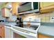 Bright kitchen featuring wood cabinets, stainless steel appliances, tile flooring, and neutral countertops at 420 Zephyr Rd, Venice, FL 34293