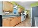 Bright kitchen featuring wood cabinets, stainless steel appliances, tile flooring, and neutral countertops at 420 Zephyr Rd, Venice, FL 34293