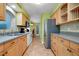 Efficient kitchen layout featuring plenty of cabinetry, stainless-steel refrigerator, and modern appliances at 420 Zephyr Rd, Venice, FL 34293
