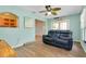 Bright living room with blue walls features a ceiling fan, stylish flooring and a comfortable loveseat at 420 Zephyr Rd, Venice, FL 34293