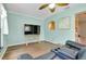 Living room features ceiling fan, laminate floors, and neutral walls, with a view of kitchen through an arch at 420 Zephyr Rd, Venice, FL 34293