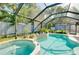Inviting screened-in pool and spa area with lush plants for privacy and relaxation at 420 Zephyr Rd, Venice, FL 34293