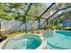 Inviting screened-in pool and spa area with lush plants and privacy at 420 Zephyr Rd, Venice, FL 34293