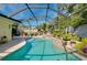Screened-in pool area featuring a custom pool design, mature landscaping, and an inviting backyard at 420 Zephyr Rd, Venice, FL 34293