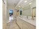 Bright bathroom featuring a spacious vanity, tile floors, and direct access to the screened-in pool area at 4358 Via Del Villetti Dr, Venice, FL 34293